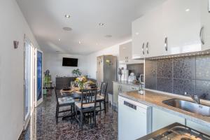 a kitchen with a table and chairs in a kitchen at Welcome To The Relax Zone in Los Caideros