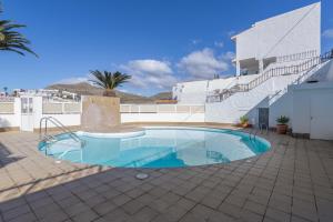 a swimming pool in front of a white building at Welcome To The Relax Zone in Los Caideros