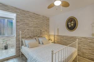 a white bed in a room with a brick wall at Welcome To The Relax Zone in Los Caideros +19 photos