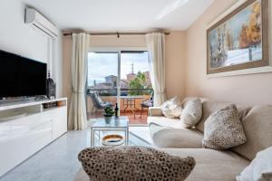 a living room with a couch and a tv at Penthouse 3-bedroom duplex in Mijas