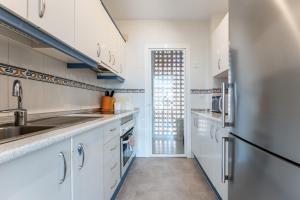 a kitchen with white cabinets and a stainless steel refrigerator at Penthouse 3-bedroom duplex in Mijas