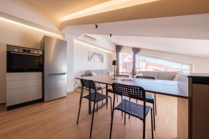 a kitchen and dining room with a table and chairs at Lumeriam Sea Loft in Roccalumera
