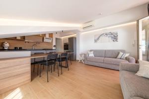 a kitchen and living room with a couch and a table at Lumeriam Sea Loft in Roccalumera +19 photos