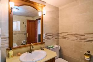 a bathroom with a sink and a mirror and a toilet at Casa Romo 2 in Rute +25 photos