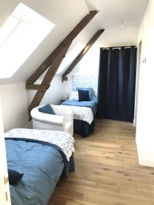 a attic bedroom with two beds and a window at Moulin De La Benatre in Entrammes