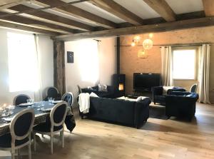 a living room with couches and tables and a television at Moulin De La Benatre in Entrammes
