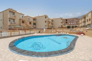 a swimming pool in front of some apartment buildings at Apartamento Afirama 1 in Araya