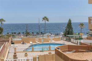 a swimming pool with the ocean in the background at Apartamento Afirama 1 in Araya
