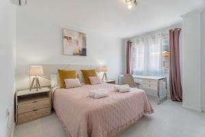 a white bedroom with a bed and a desk at Apartamento Afirama 1 in Araya +21 photos