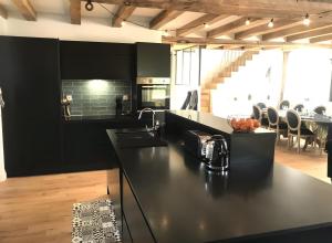a kitchen with black cabinets and a black counter top at Moulin De La Benatre in Entrammes