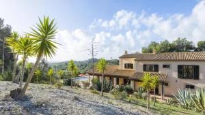 a house with palm trees in front of it at Son Aladern in Islas Baleares