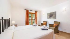 a bedroom with two beds and two chairs at Son Aladern in Islas Baleares +30 photos