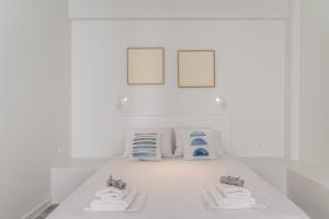 a white room with towels and pictures on the wall at A Tinian Room 4 in Tinos