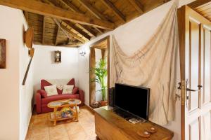 a living room with a tv and a red couch at Casa Rural Ciso in Tijarafe