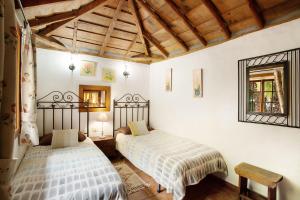 two beds in a room with white walls and wooden ceilings at Casa Rural Ciso in Tijarafe