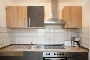 a kitchen with a sink and a stove and cabinets at Ferienpark Oberallgäu Haus 1 in Missen-Wilhams