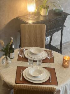 a table with plates and wine glasses on it at La Cure Vosgienne in Champdray