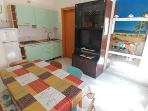 a kitchen with a table and a refrigerator at Euroholiday Village 3G in Lido di Jesolo