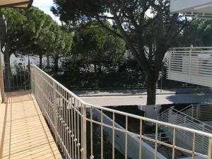 a white railing on a walkway next to a tree at Euroholiday Village 3G in Lido di Jesolo