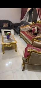 a living room with two beds and a table at Pyramids & GEM Tourist Apartment in ‘Ezbet `Abd el-Ḥamîd