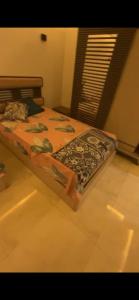 a bedroom with a bed with a blanket on it at Pyramids & GEM Tourist Apartment in ‘Ezbet `Abd el-Ḥamîd