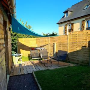 a patio with chairs and a table and a fence at Chalet Honfleur in Honfleur +8 photos