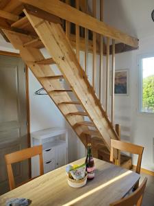 a wooden staircase in a kitchen with a table with a bottle of wine at Chalet Honfleur in Honfleur