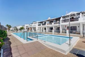 a swimming pool in front of a building at Plus Romance in Puerto del Carmen