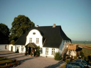 a large white house with a black roof at Ferien Auf Dem Lande in Scheggerott