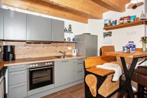 a kitchen with gray cabinets and a wooden table at Naturhäusle Oberschwaben in Ebersbach-Musbach