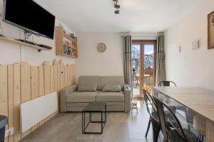 a living room with a couch and a table at Appartement St so in Saint-Sorlin-dʼArves