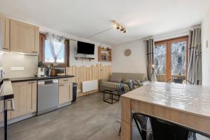a kitchen and living room with a counter and a table at Appartement St so in Saint-Sorlin-dʼArves
