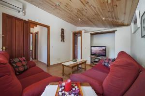 a living room with red couches and a tv at Las Palmeras in El Port