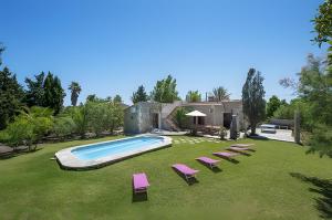 a yard with a swimming pool and chairs and a house at Las Palmeras in El Port