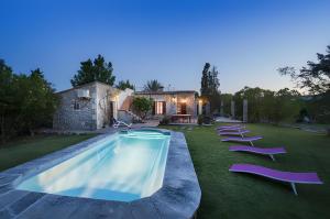 a pool with lounge chairs in a yard with a house at Las Palmeras in El Port
