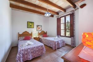 a bedroom with two beds and a window at Las Palmeras in El Port +10 photos