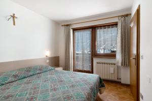 a bedroom with a bed and a window at cèsa Maria Suen in Canazei