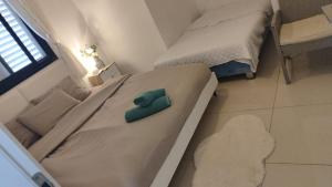 a bed with a green pillow on it in a room at על הים in Nahariyya