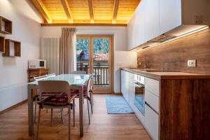 a kitchen with a table and a dining room at Condominio Lucia 12 Pinzolo in Pinzolo