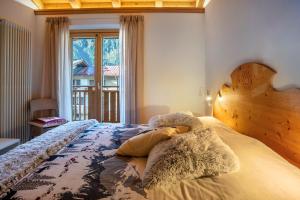 a bedroom with a bed with a wooden headboard and a window at Condominio Lucia 12 Pinzolo in Pinzolo
