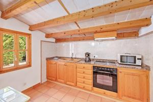 a kitchen with a stove and a microwave at Finca L'hort Nou in Pollença