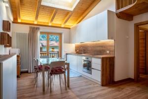 a kitchen with a table and a dining room at Condominio Lucia 12 Pinzolo in Pinzolo +23 photos