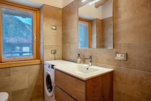 a bathroom with a sink and a washing machine at Condominio Lucia 12 Pinzolo in Pinzolo