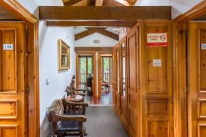a hallway with wooden doors and chairs in a house at Casa Rural El Agero in Cabañes
