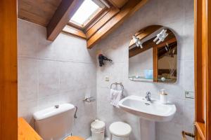 a bathroom with a sink and a toilet and a mirror at Casa Rural El Agero in Cabañes +26 photos