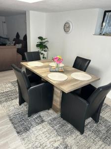 a dining room table with black chairs and a table at Ferienwohnung Princesa in Geilenkirchen +3 photos