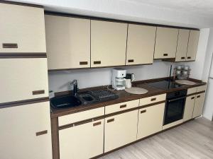 a kitchen with white cabinets and a sink at Ferienwohnung Princesa in Geilenkirchen