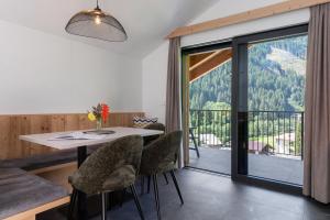 a dining room with a table and chairs and a balcony at Mountain Chalet Tribulaun Pflersch in Colle Isarco
