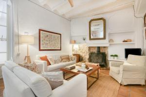 a living room with white furniture and a fireplace at Ca la Pasita 26 in Beniali