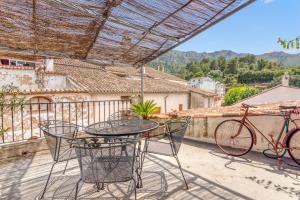 a patio with a table and a bike on a balcony at Ca la Pasita 26 in Beniali